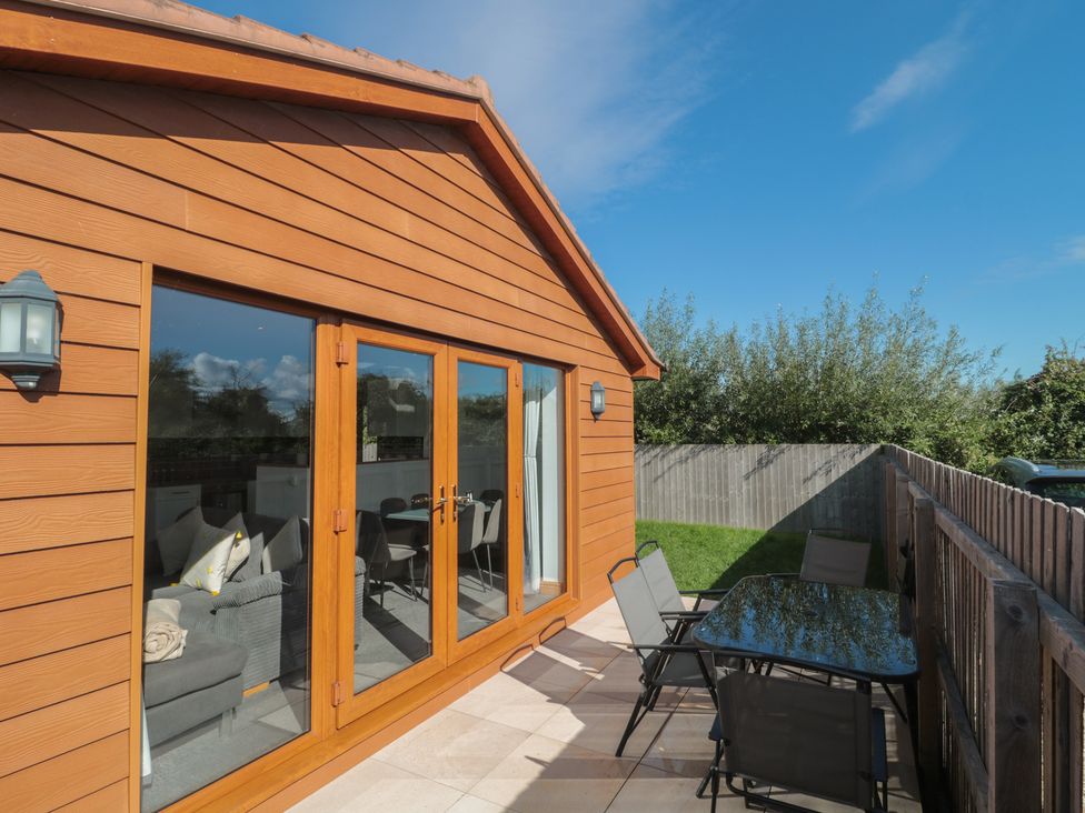 An outdoor patio with a table and chairs at Bluebell Lodge, Meadow view lodges Brean