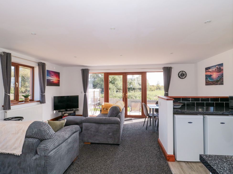 A living room with a sofa and television at Delphine Lodge, Meadow View Lodges Brean