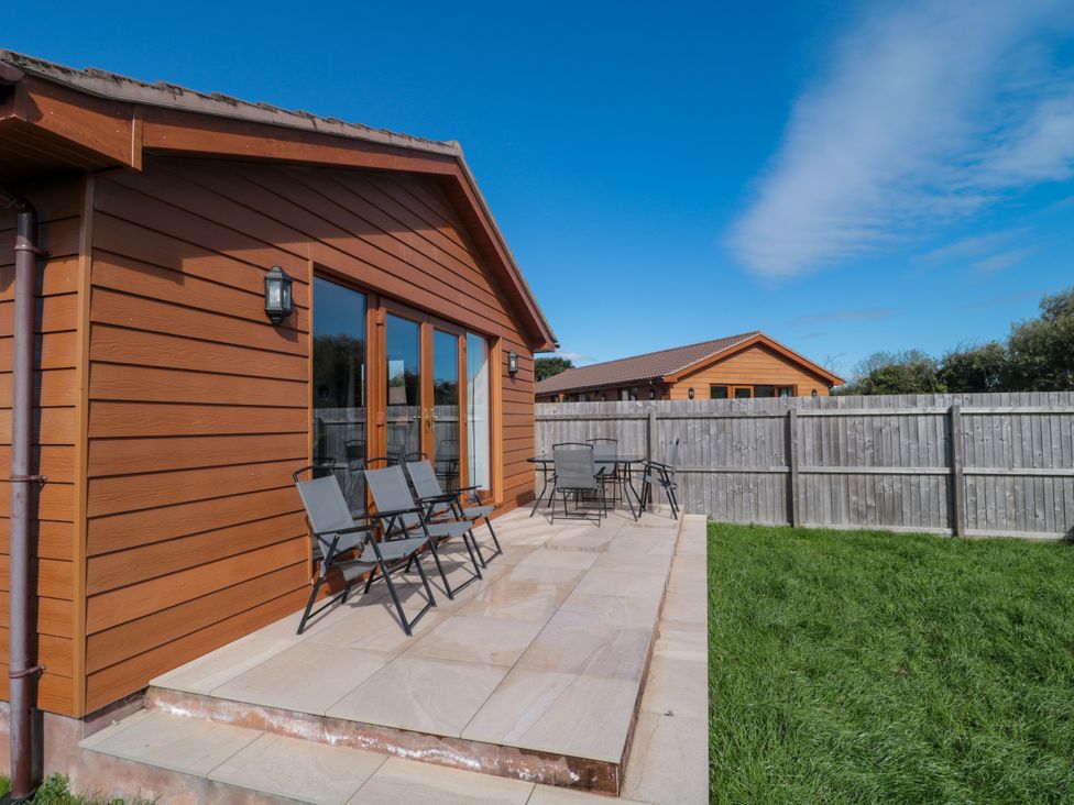 An outdoor area with patio chairs at Delphine Lodge, Meadow View Lodges, Brean