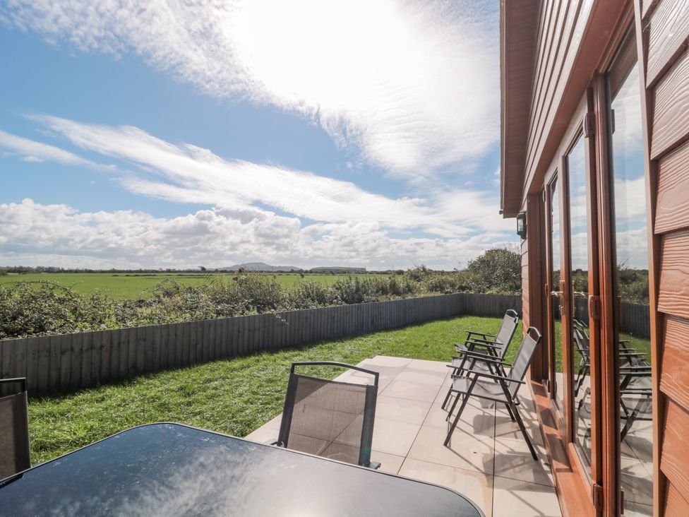 An outdoor seating area with a table and chairs at Delphine Lodge, Meadow View Lodges Brean