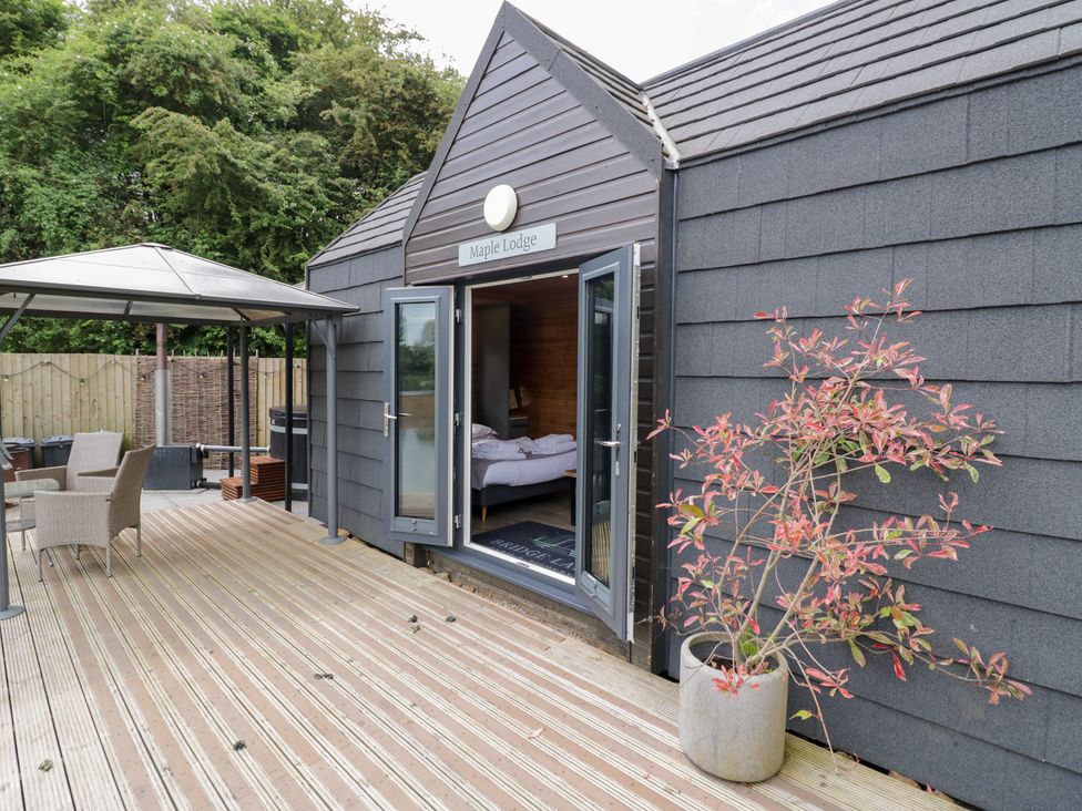 An outdoor area with a wooden deck and gazebo at Maple Lodge at Bridge Lake Farm & Fishery, Chacombe