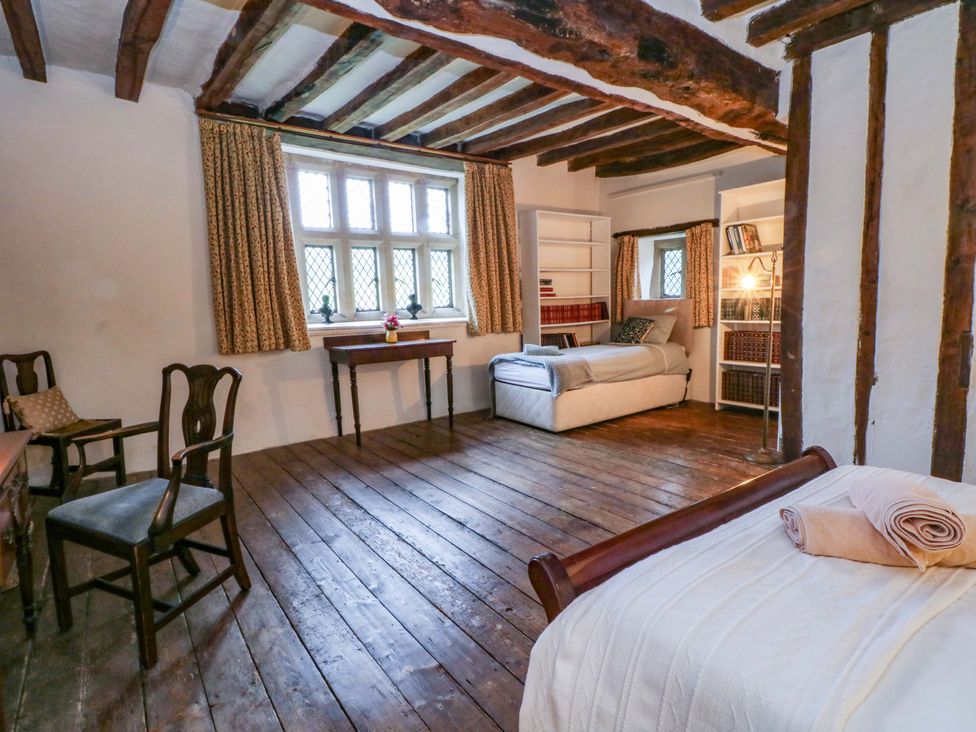A bedroom with a bed and a table at Y Fferm in Pontblyddyn