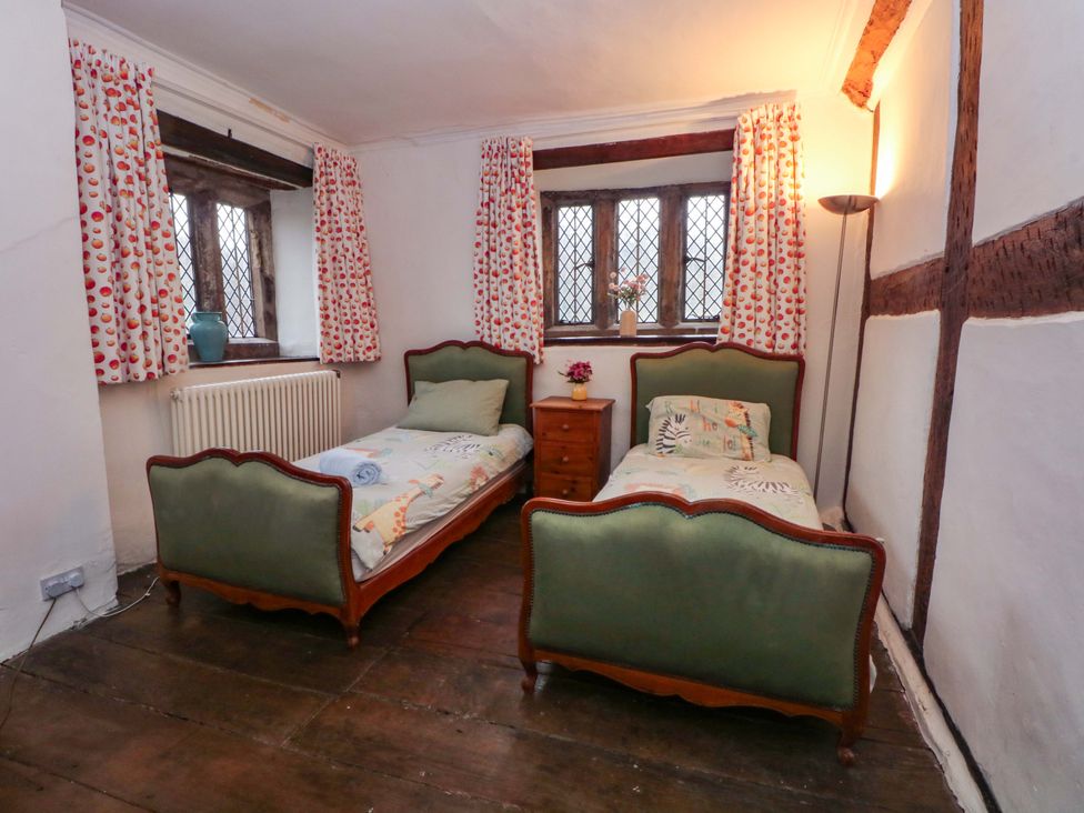 A bedroom with two beds and a nightstand at Y Fferm in Pontblyddyn