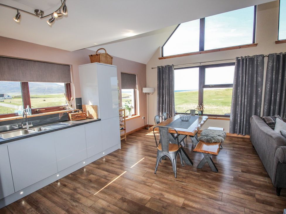 A kitchen with a dining area and a sofa at Otter Cottage Scarista near Leverburgh