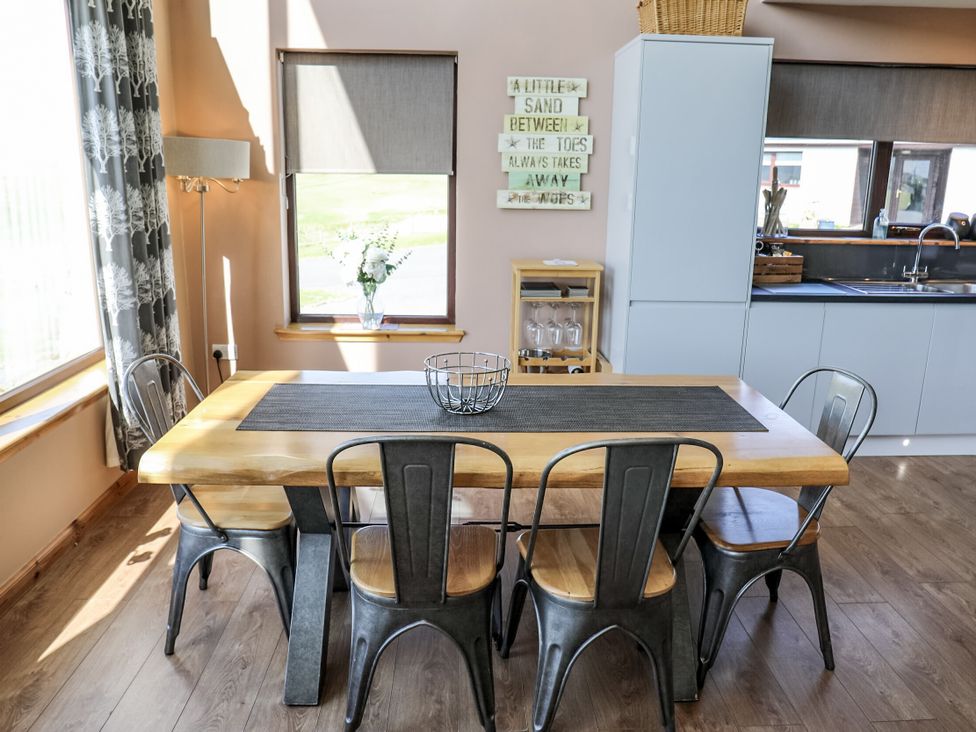 A dining room with a table and chairs at Otter Cottage in Scarista near Leverburgh