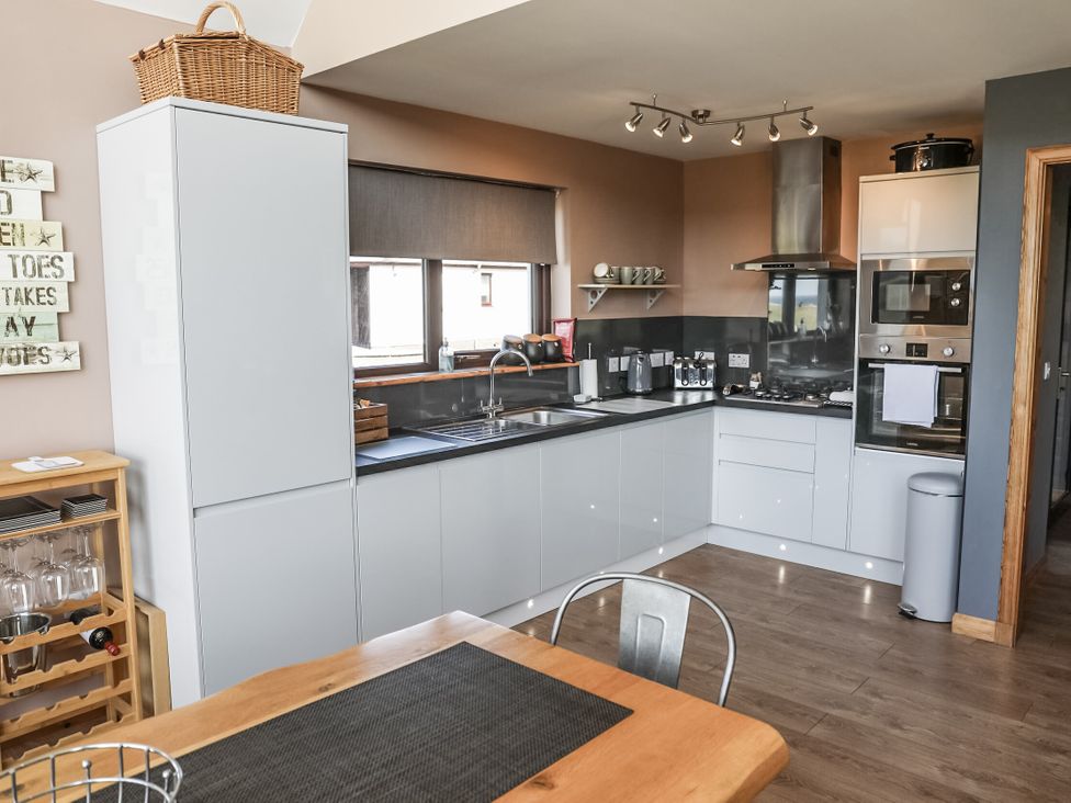 A kitchen with a sink and stove at Otter Cottage near Leverburgh
