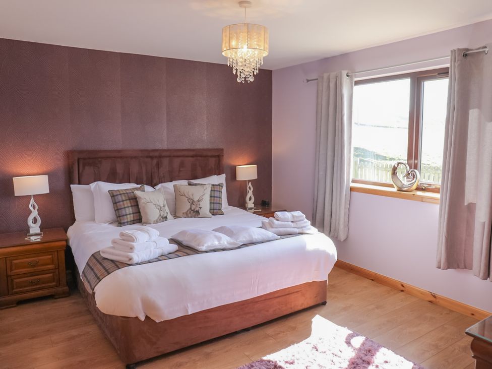 A bedroom with a double bed and bedside tables at Otter Cottage Scarista near Leverburgh