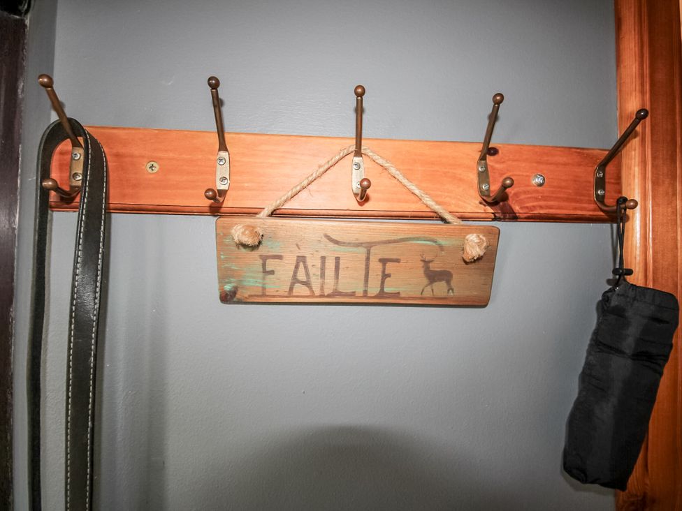 An entryway with coat hooks and a sign at Otter Cottage Scarista near Leverburgh