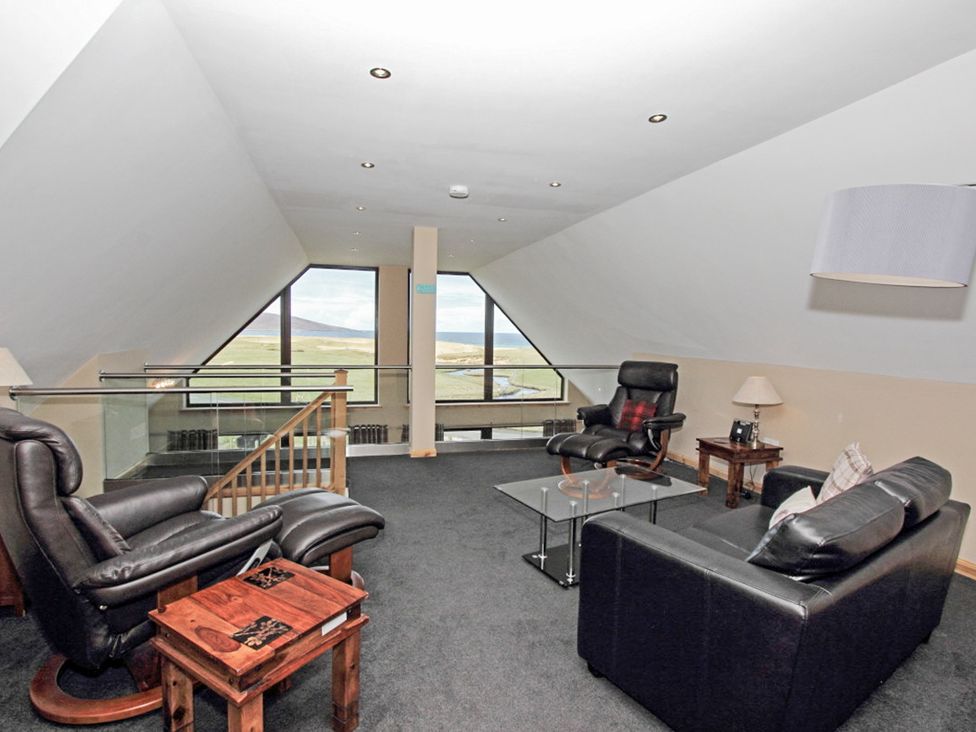 A living room with a sofa and recliner chairs at Otter Cottage in Scarista near Leverburgh
