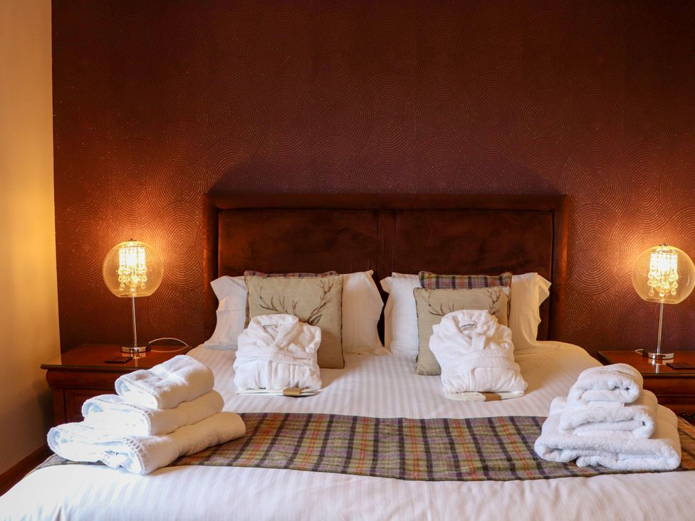 A bedroom with a bed and towels arranged at Otter Cottage Scarista near Leverburgh