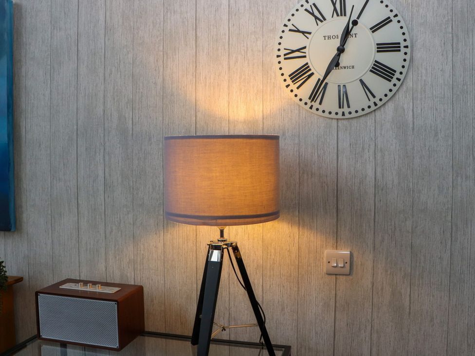 A lamp and clock on a wall at Otter Cottage in Scarista near Leverburgh