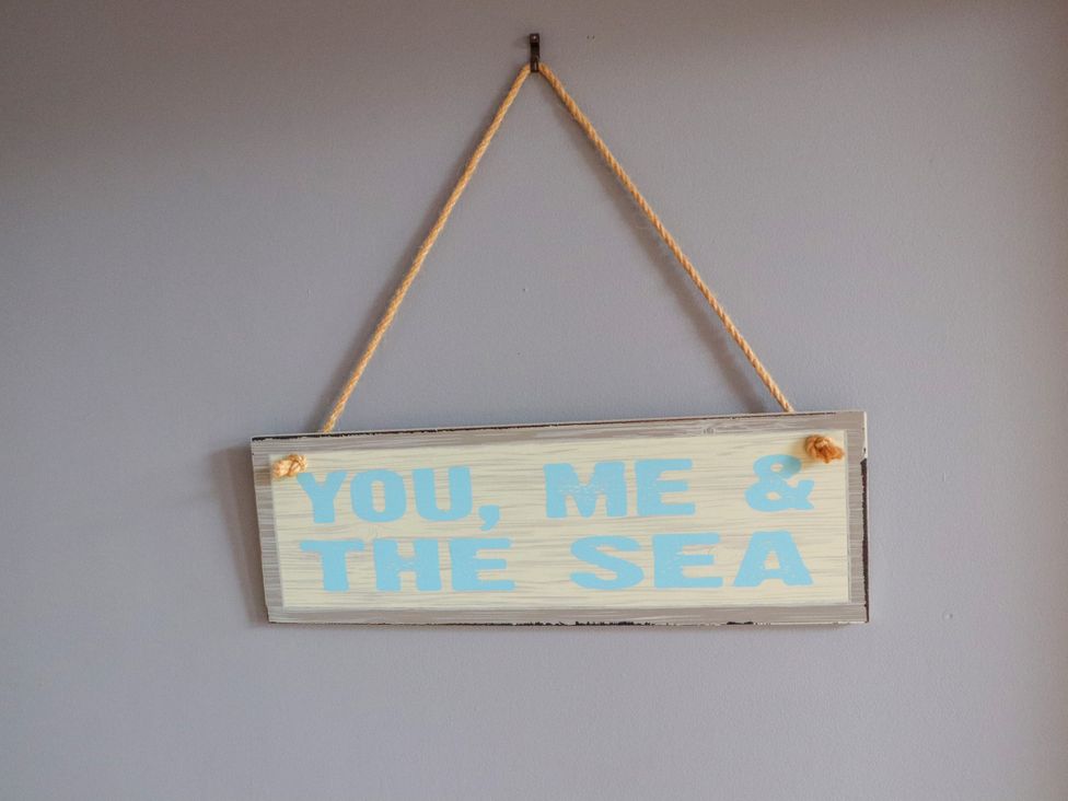 A sign with the text 'YOU, ME & THE SEA' hung on a wall at Otter Cottage, Scarista near Leverburgh