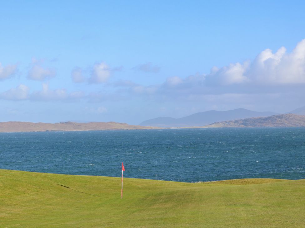 A view of a golf course with sea and clouds at Otter Cottage Scarista near Leverburgh