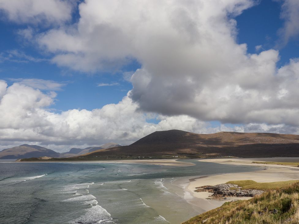 A beach with mountains and clouds at Otter Cottage Scarista near Leverburgh
