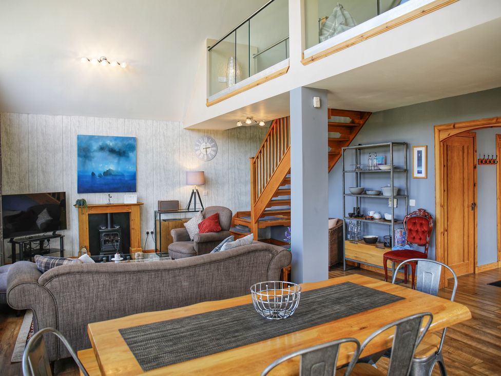 A living room with a television and a sofa at Corncrake Cottage in Leverburgh