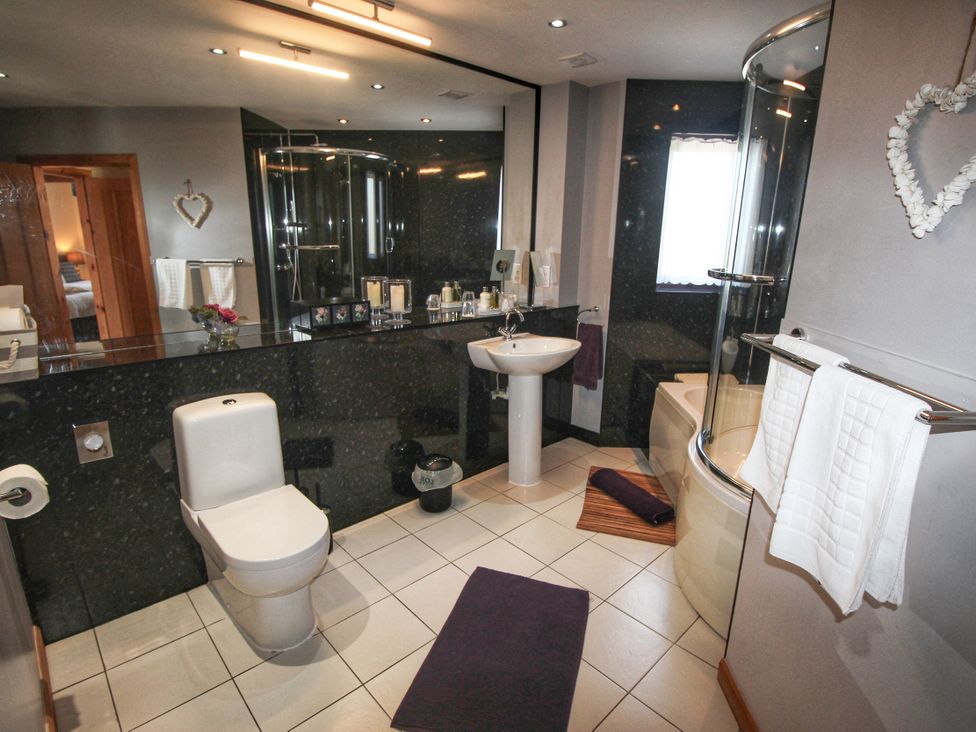 A bathroom with a shower and bathtub at Corncrake Cottage Leverburgh