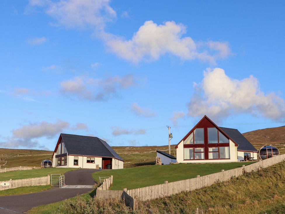 Two houses with a garden and a road at Corncrake Cottage in Leverburgh