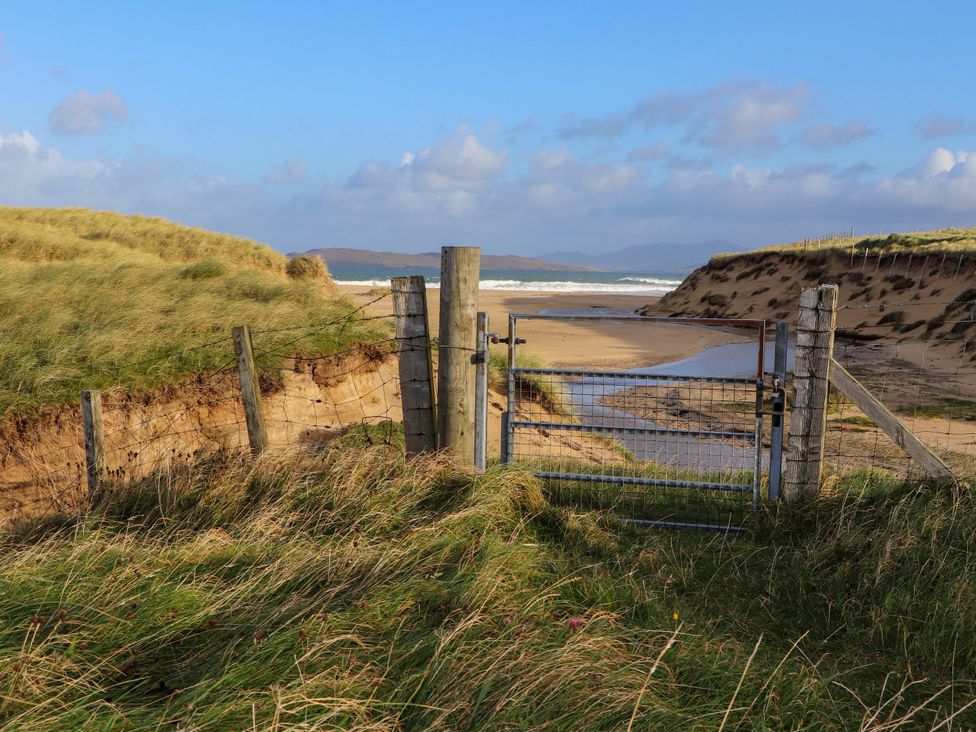 A gate leading to a beach area at Corncrake Cottage in Leverburgh
