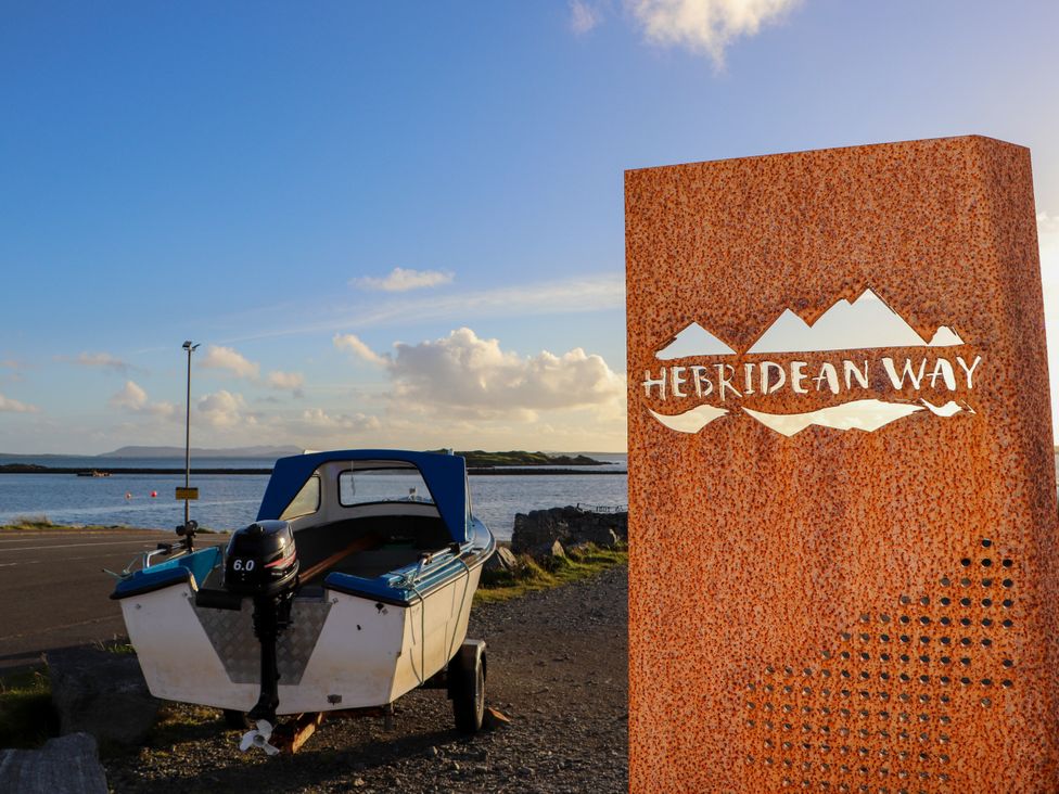 A boat near a sign at Hebridean Way in Leverburgh