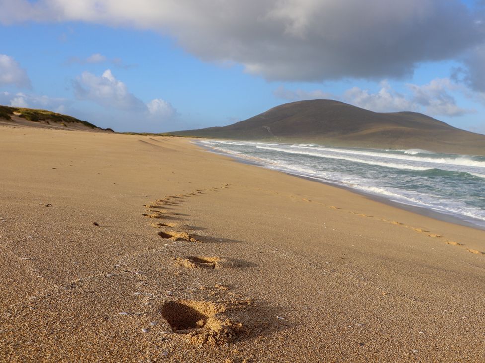 Footprints on the sand by the ocean at Corncrake Cottage Leverburgh