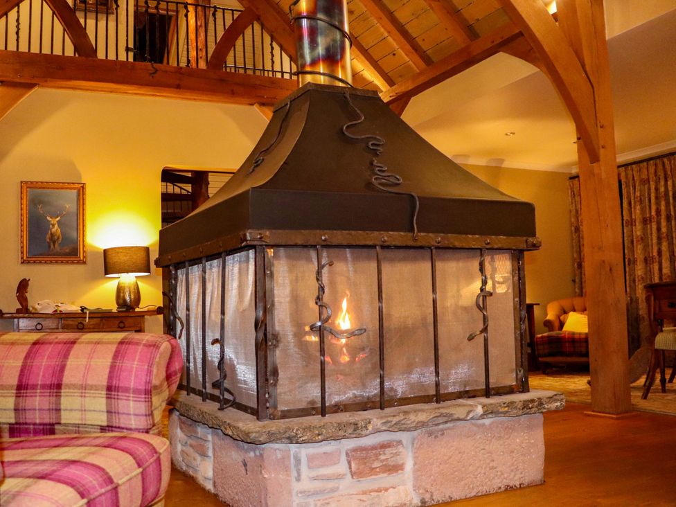 A living room with a central fireplace and sofa at Glen Cruick in Kirriemuir