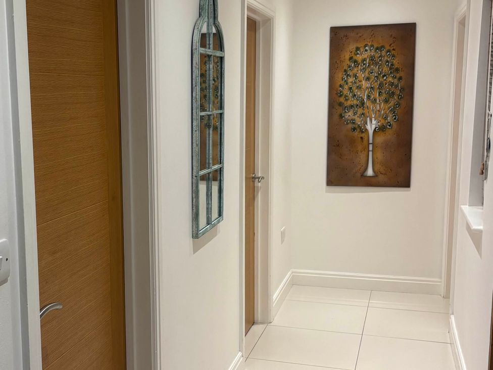 A hallway with a mirror and artwork at Dreamwood Lodge in Keston near Leaves Green