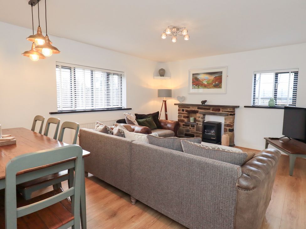 A living room with a sofa and dining table at Glen Lea in Giggleswick, Settle