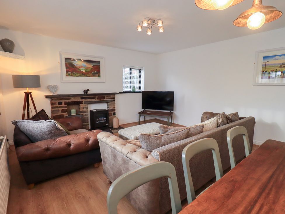 A living room with a television, sofa and coffee table at Glen Lea in Giggleswick, Settle