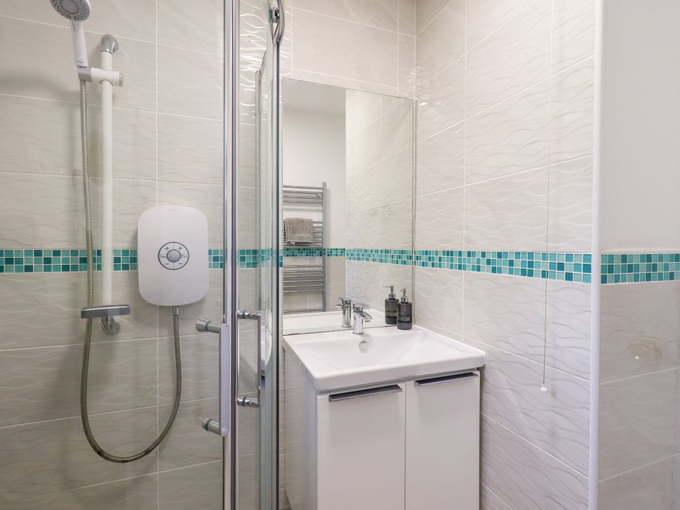 A bathroom with a shower and sink at Glen Lea in Giggleswick, Settle