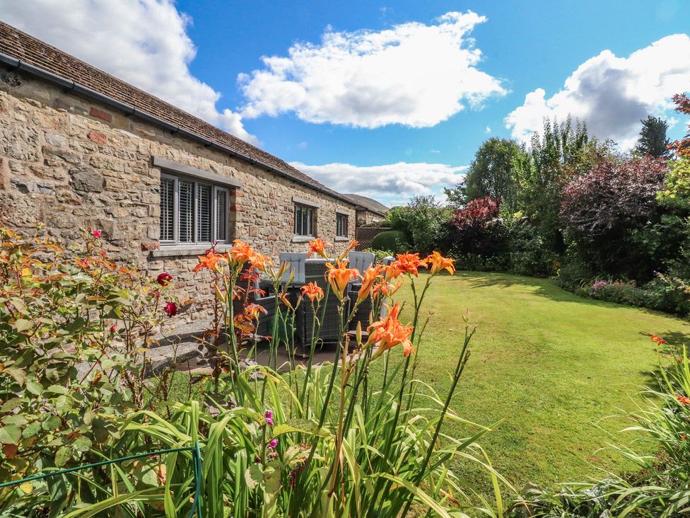 A garden with flowers and stone wall at Glen Lea in Giggleswick, Settle