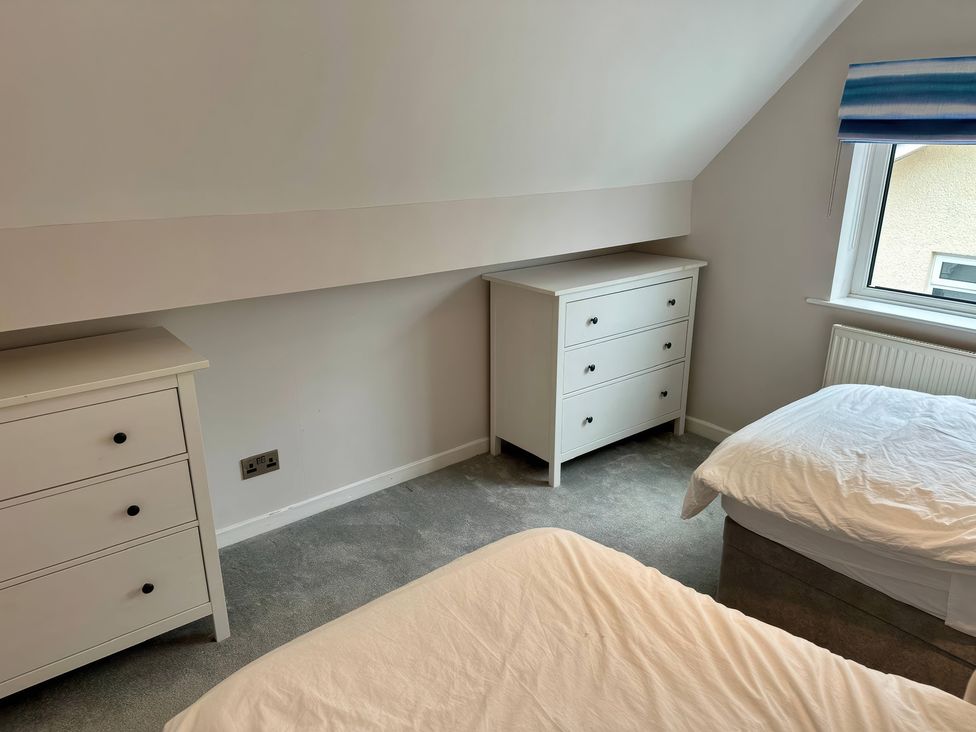 A bedroom with two beds and two dressers at Swn Y Mor in Benllech