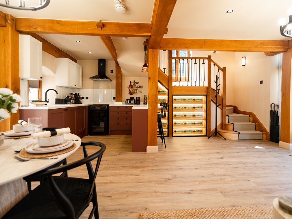 A kitchen with dining table and staircase at Dovecote East Langdon near St Margaret's At Cliffe
