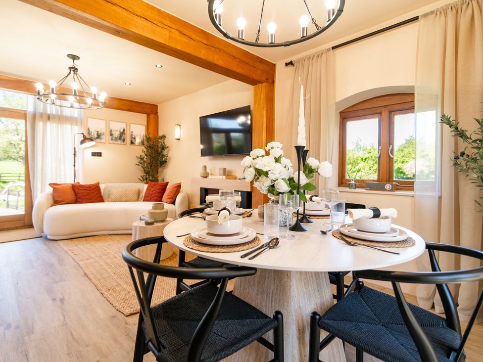 A living room with a sofa, dining table, and a television at Dovecote in East Langdon near St Margaret's At Cliffe