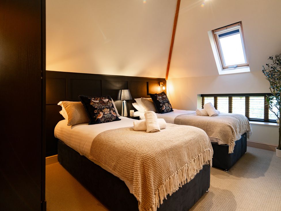 A bedroom with two beds and a window at Dovecote in East Langdon near St Margaret's At Cliffe