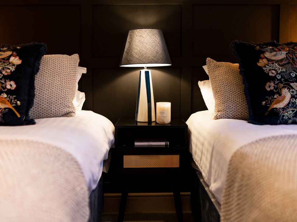 A bedroom with two beds and a nightstand at Dovecote East Langdon near St Margaret's At Cliffe