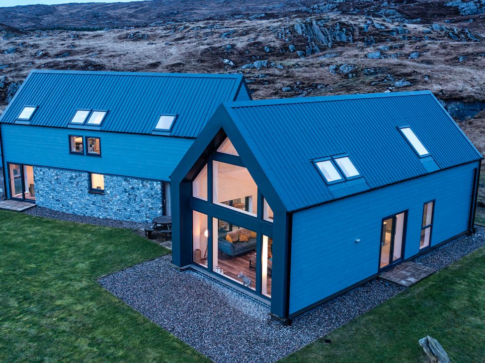 An exterior view of a house with blue roof and windows at Taigh Rona Luskentyre Isle Of Harris