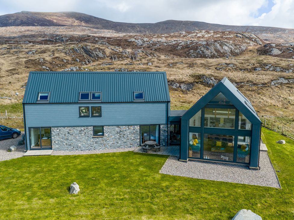 A house with a stone wall and grass area at Taigh Rona Luskentyre Isle Of Harris