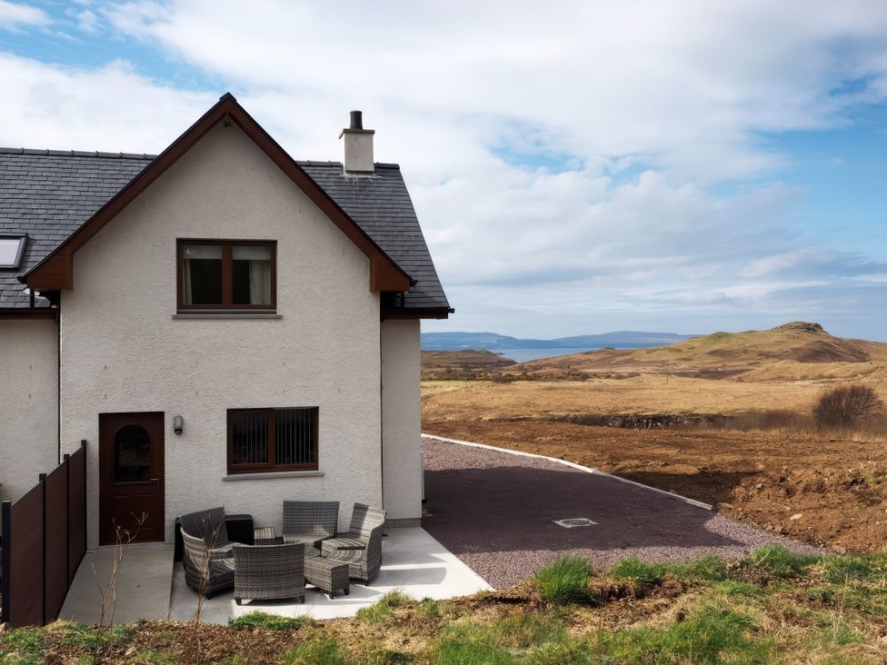 An outdoor view of a house with seating area at Falls Cottage in Uig