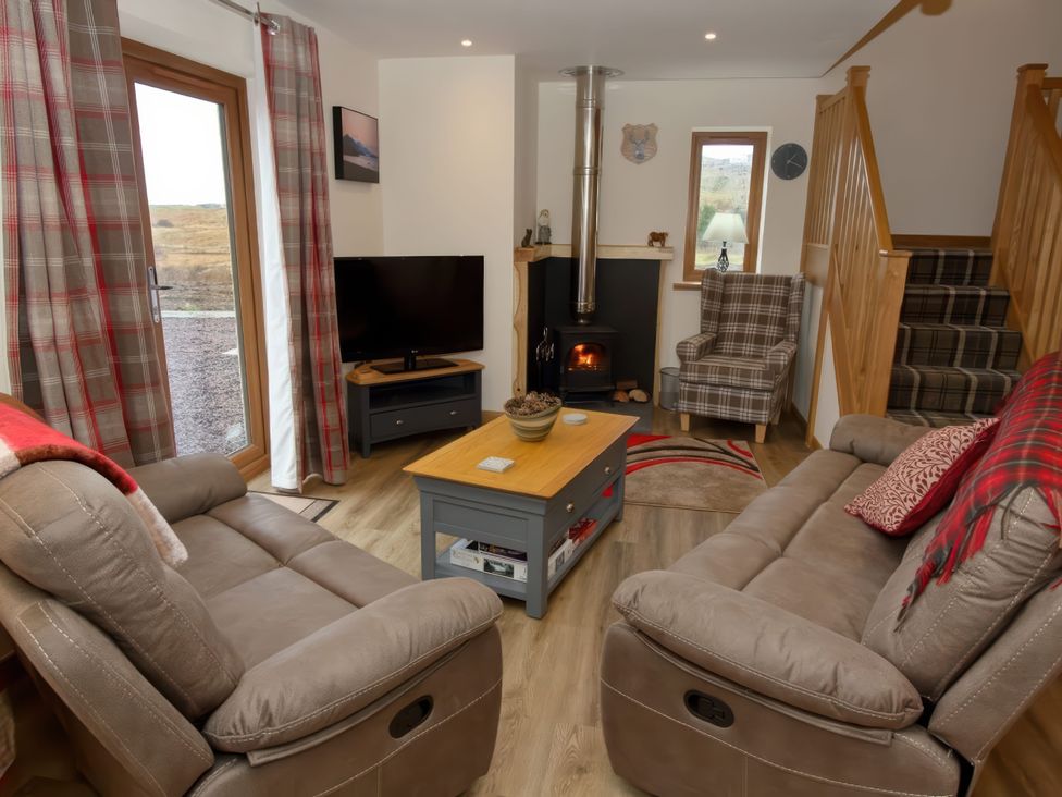 A living room with a sofa and fireplace at Falls Cottage in Uig