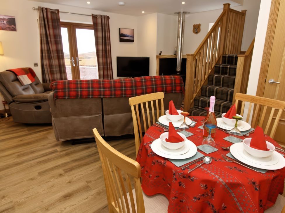 A living room with a sofa and dining area at Falls Cottage Uig