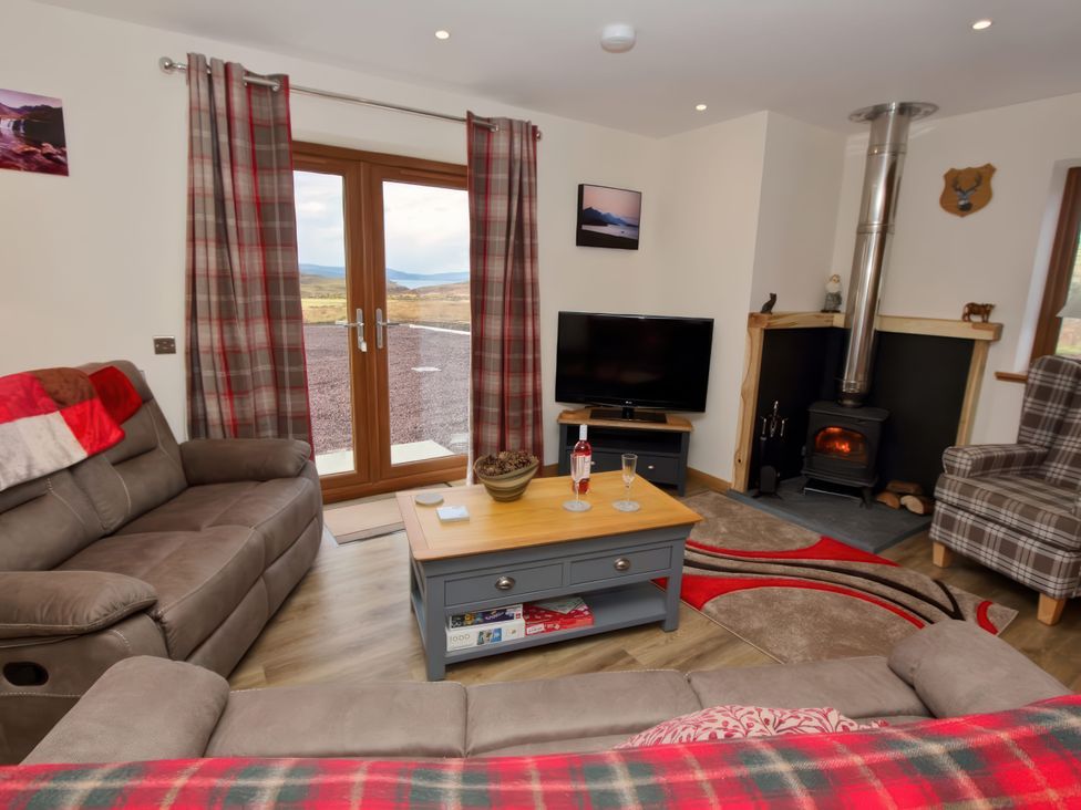 A living room with a sofa and a television at Falls Cottage in Uig