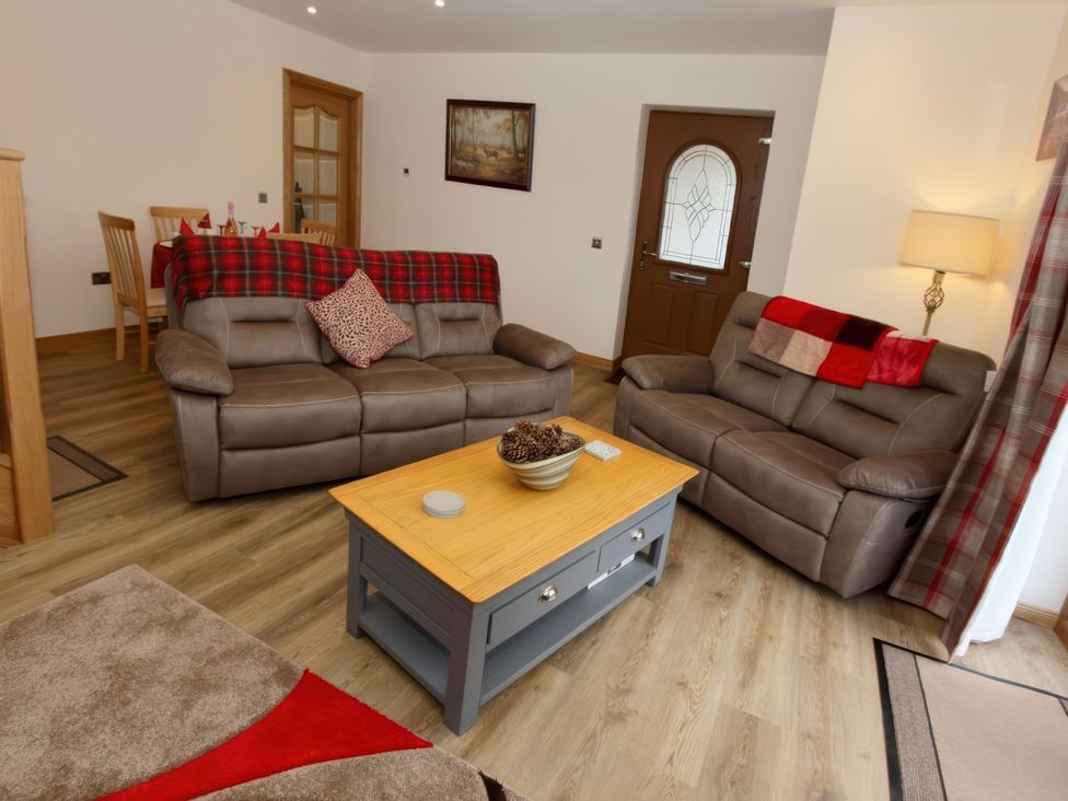 A living room with seating and dining area at Falls Cottage in Uig