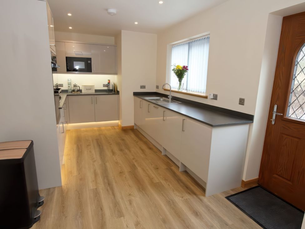 A kitchen with cabinets and a sink at Falls Cottage in Uig