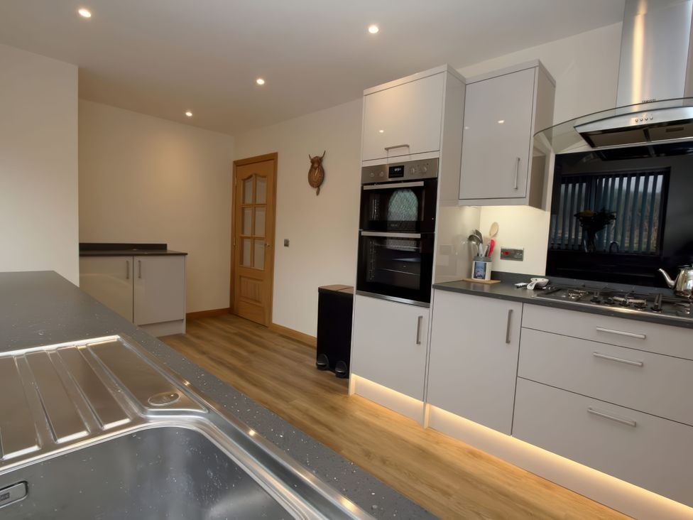 A kitchen with appliances and worktop at Falls Cottage in Uig