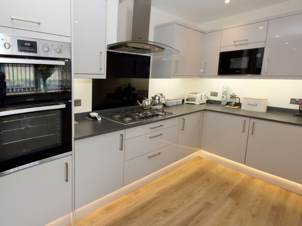 A kitchen with appliances and cupboards at Falls Cottage in Uig