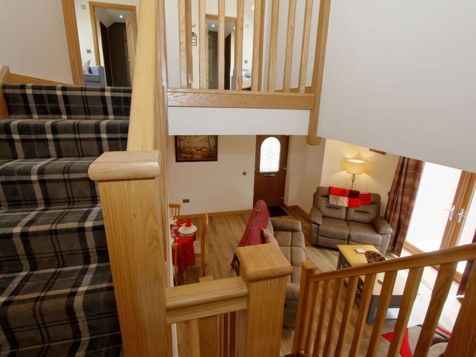 A living room with staircase and door at Falls Cottage in Uig
