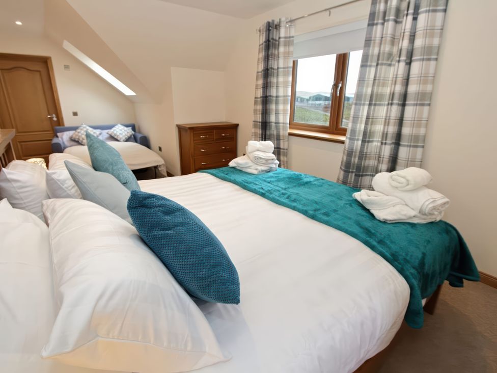 A bedroom with a bed and a couch at Falls Cottage Uig
