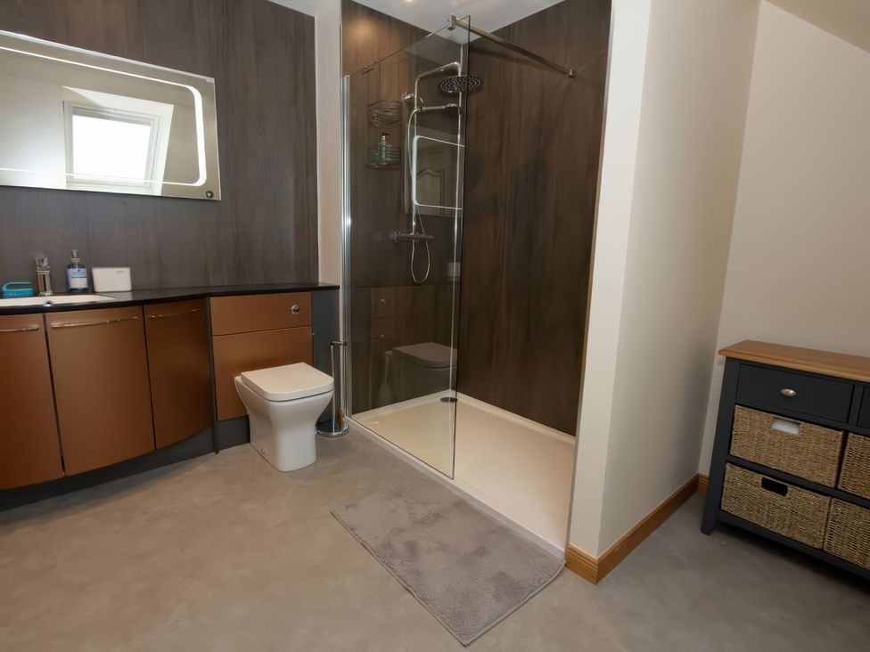 A bathroom with shower, toilet, and vanity at Falls Cottage Uig