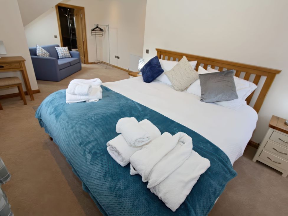 A bedroom with a bed and towels on it at Falls Cottage in Uig