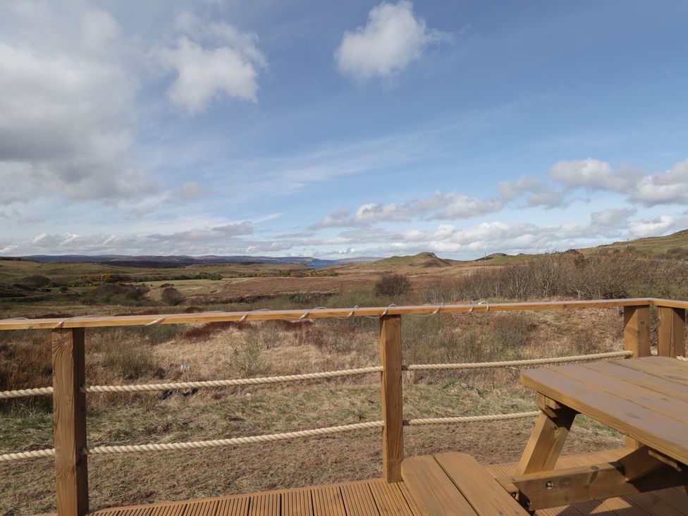 A view of a landscape with a wooden deck at Falls Cottage in Uig